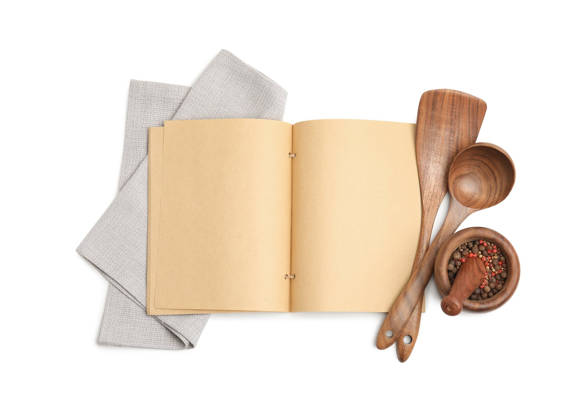 Blank recipe book, spices and wooden utensils on a white background ready to become a cookbook