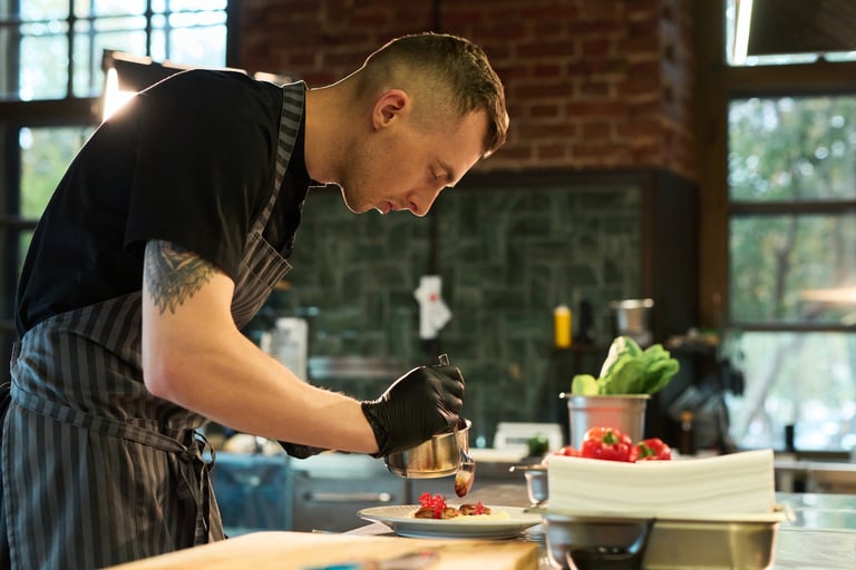 Chef preparing and plating dishes in a professional kitchen, the recipes our team develops into cookbooks